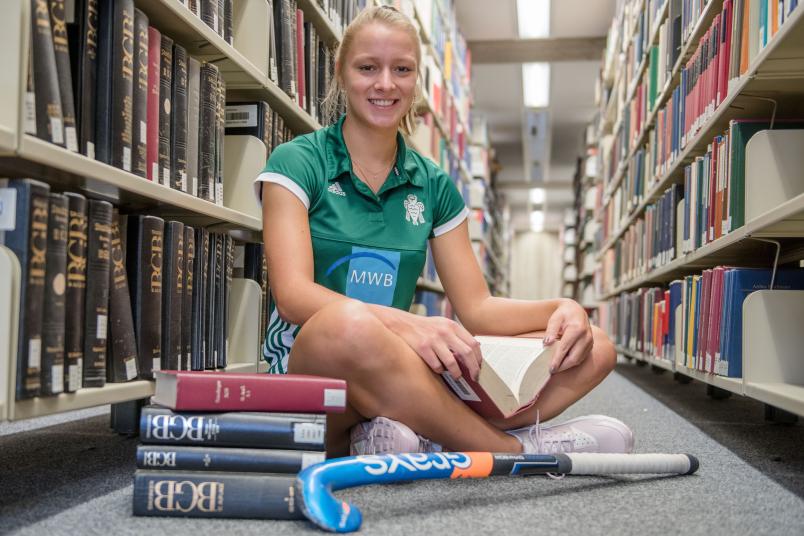 Hockeyspielerin im Trikot in der Unibibliothek