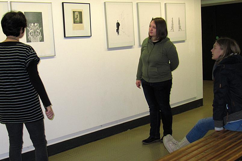 Objekte einer Kunstausstellung werden betrachtet