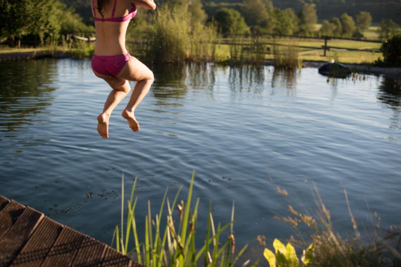 Frau springt in Fluß