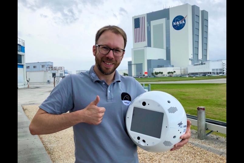Christian Karrasch hält Roboter Cimon im Arm.