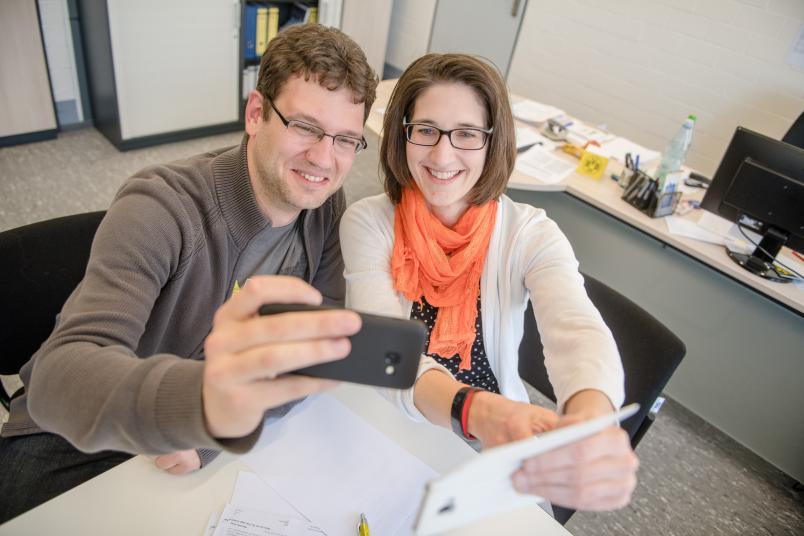 Zwei Personen machen Selfies mit zwei Handys