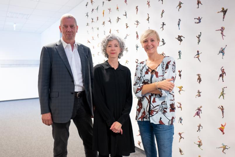 Drei Personen vor Kunstwerk