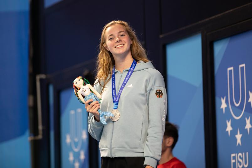 Lisa Höpink freut sich nach erfolgreichem Rennen über ihre Silbermedaille im Schwimmen.