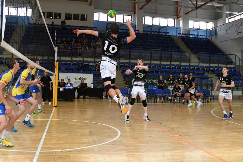 Bei einem Volleyballspiel springt ein Spieler am Netz zum Ball.