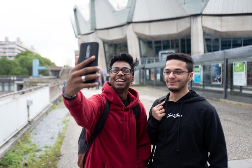 Zwei Männer lachen in ein Handy