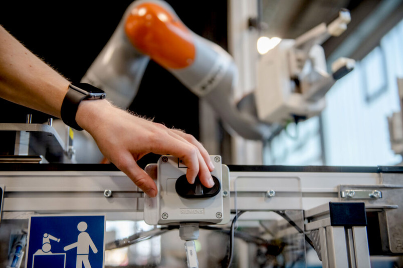 Roboter und Mensch in einer Fabrik