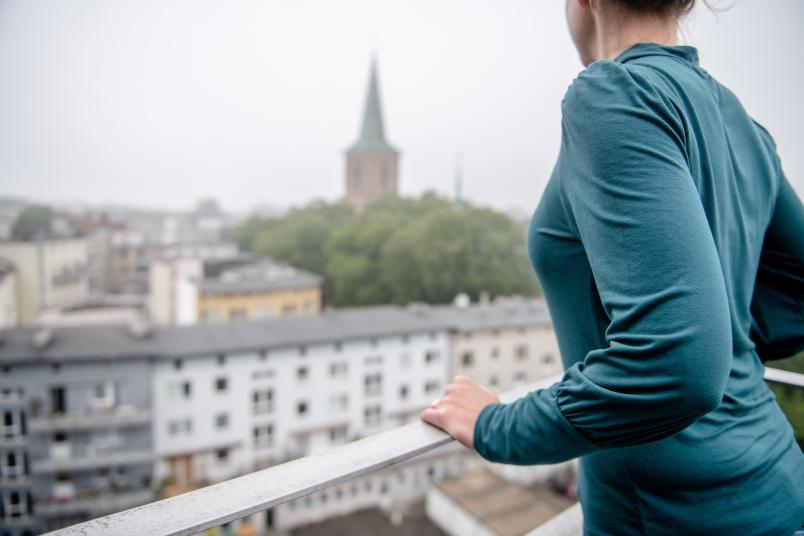 Frau steht an einem Geländer über der Tiefe