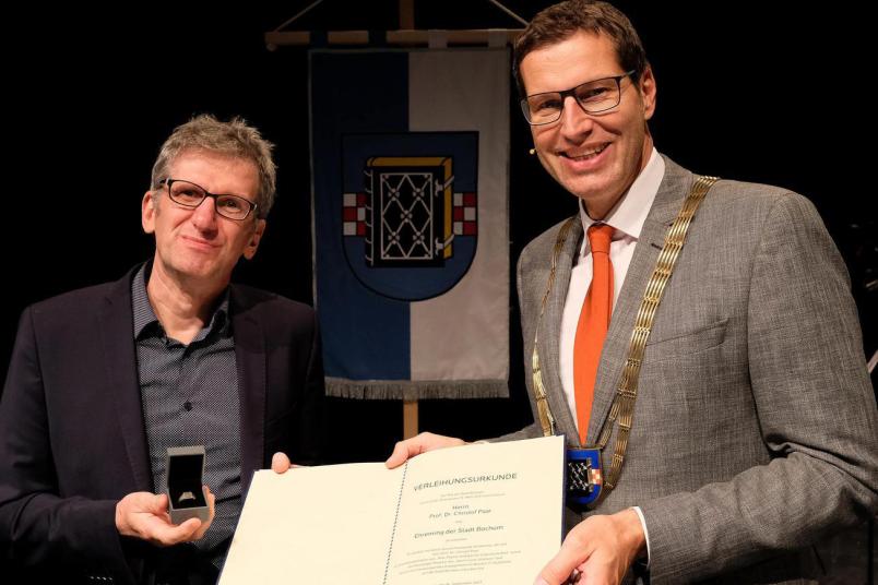 Oberbürgermeister Thomas Eiskirch (rechts) übergibt den Ehrenring an Christof Paar.