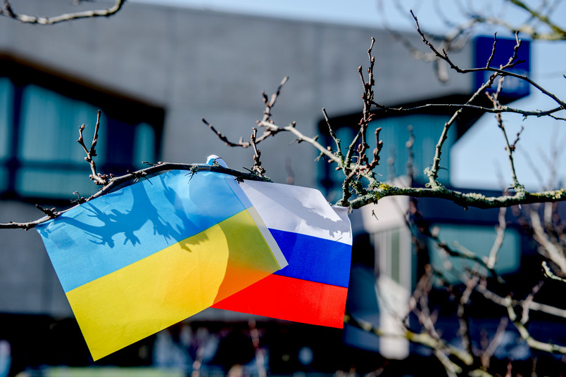 Symbolbild mit einer ukrainischen und einer russischen Flagge auf dem Campus der RUB