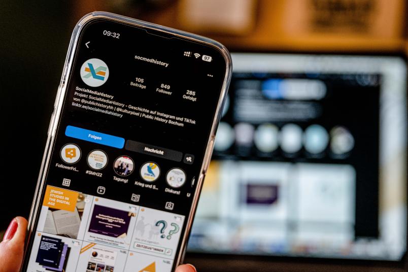 Ein Handy, auf dem das Instagram-Profil des Kanals SocialMediaHistory aufgerufen ist.