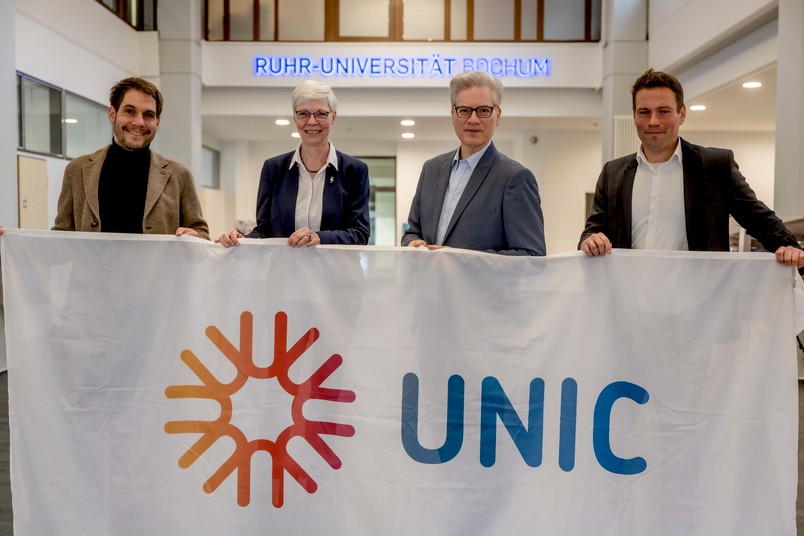 Das Team von UNIC mit dem UNIC-Banner im Foyer der Ruhr-Universität.