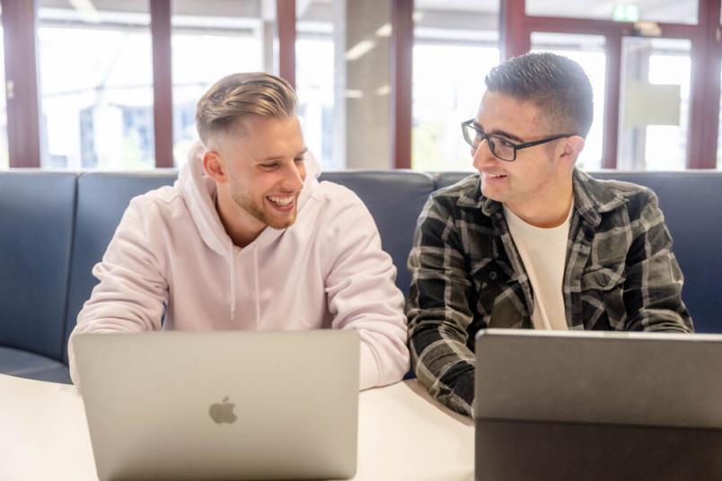 Zwei Studierende lernen an Laptops.