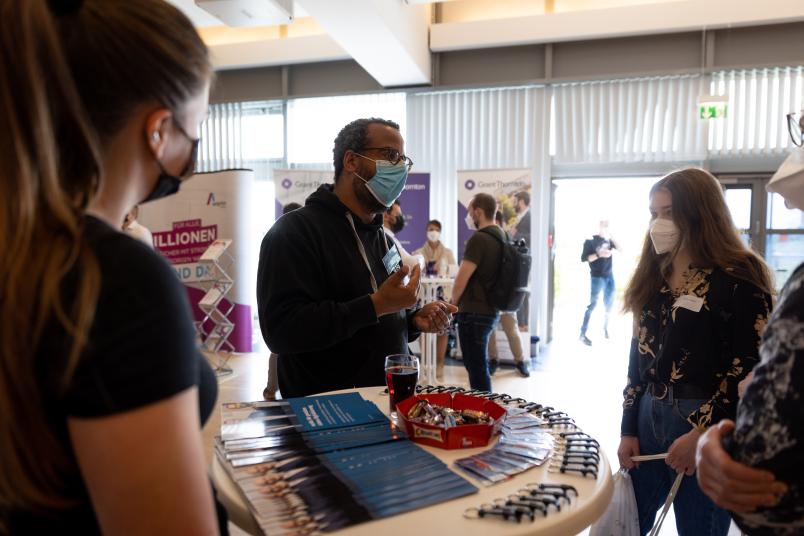 Messestand mit drei Menschen