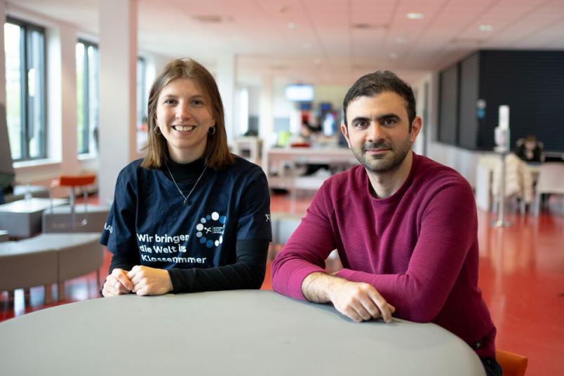 Hanna Schömann und Behnam Ghazinouir sitzen in der Cafete. 