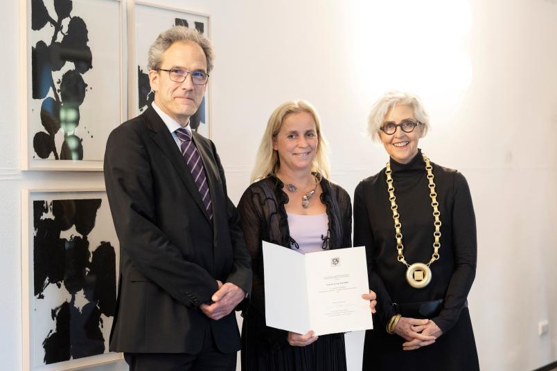 Gruppenbild mit drei Personen, in der Mitte Prof. Dr. Ilona Rolfes
