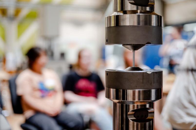 Ein Metallstift ist zwischen zwei Stempeln eingespannt