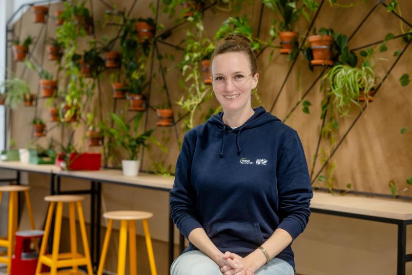 Gründungsberaterin Melusine Reimers vor einer Wand mit Pflanzen im Makerspace.