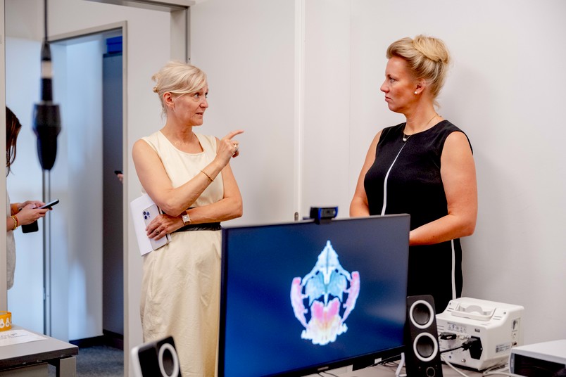 Ministerin Ina Brandes (rechts) lässt sich am Bochumer Standort des Deutschen Zentrums für Psychische Gesundheit von Sprecherin Silvia Schneider den Stand der Forschungsarbeiten erläutern.