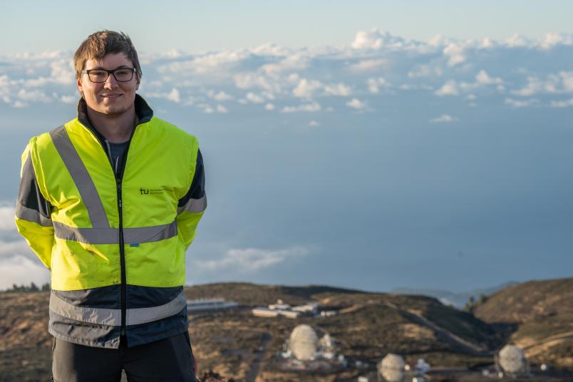 Eine Person vor mehreren Teleskopen