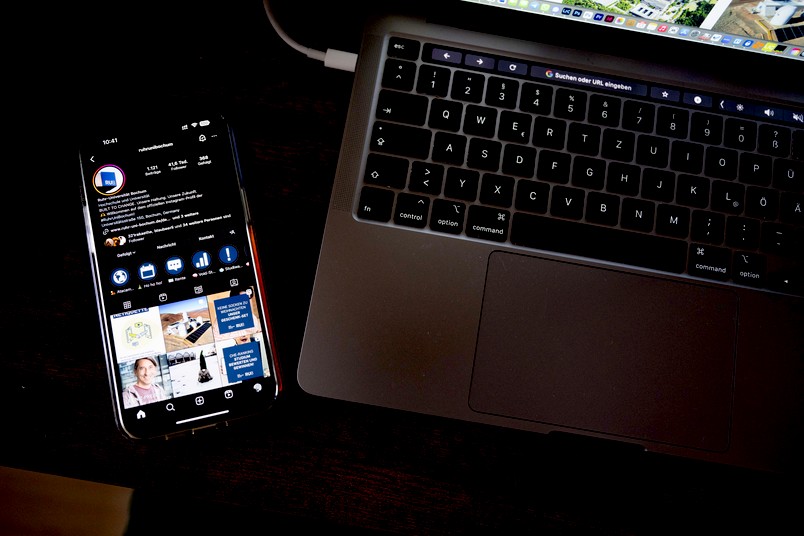 Handy mit Social-Media-Content neben einem Laptop