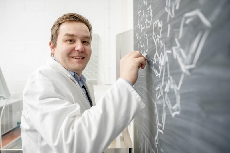 Johannes Karges schreibt Formeln an eine Tafel