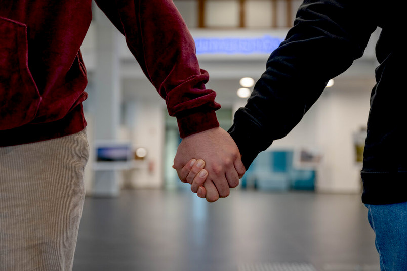 Zwei Menschen halten sich an den Händen
