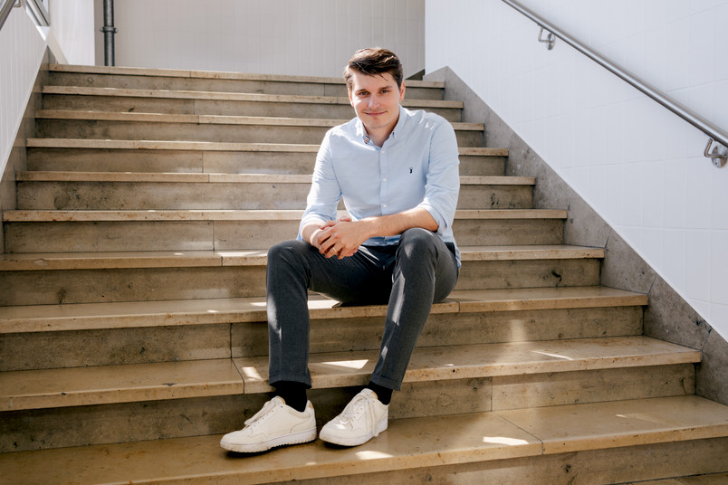 Eine Person sitzt entspannt auf einer Treppe.