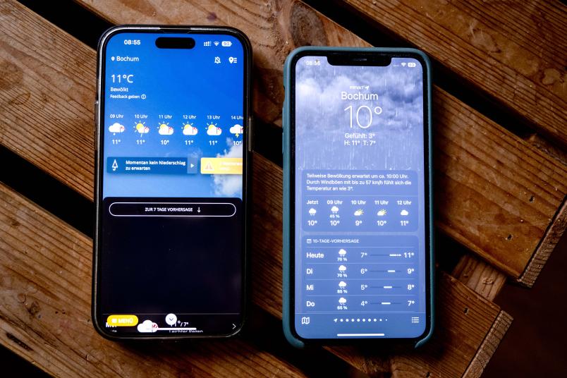Zwei Handys mit Wetter-Apps, die unterschiedliche Vorhersagen anzeigen
