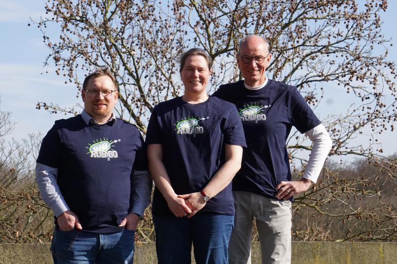 Drei Personen in T-Shirts mit dem Aufdruck "RUB 60"