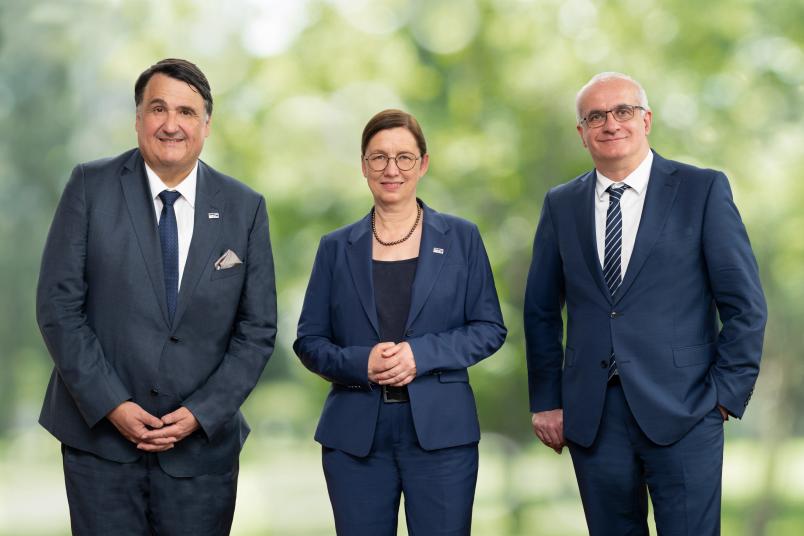 Drei Personen vor grünem Hintergrund