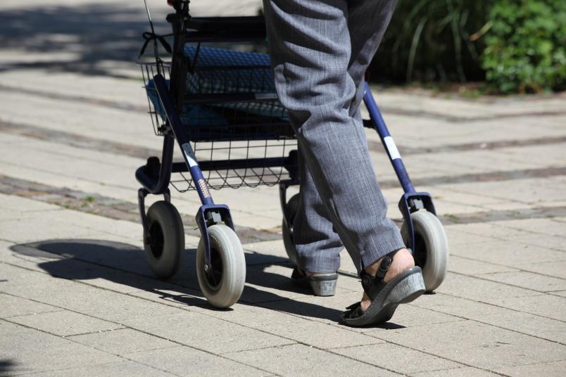 Person, die einen Rollator schiebt