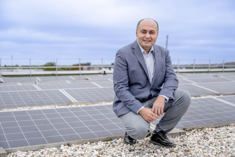 Porträt des Forschers, der vor einer Solaranlage hockt