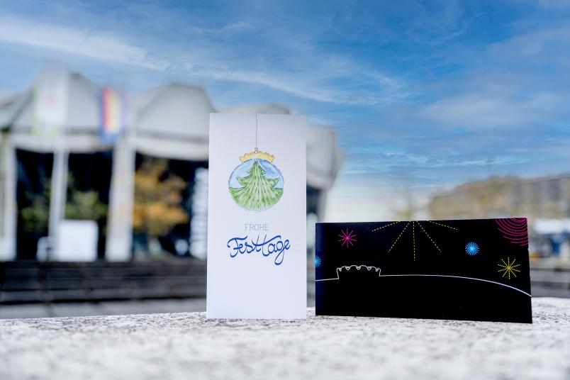 Zwei Weihnachtskarten vor Audimax