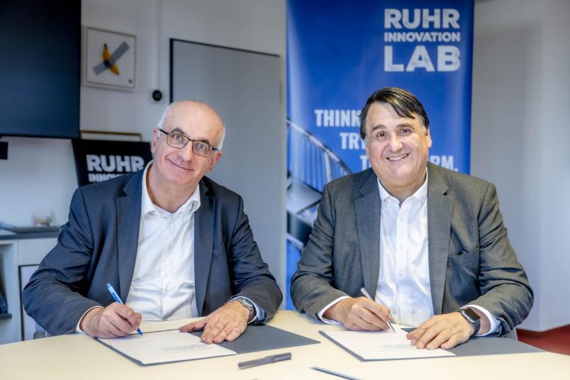 Manfred Bayer, Rektor der TU Dortmund (links), und Martin Paul, Rektor der RUB, unterzeichnen die gemeinsame Bewerbung um den Titel Exzellenzverbund.