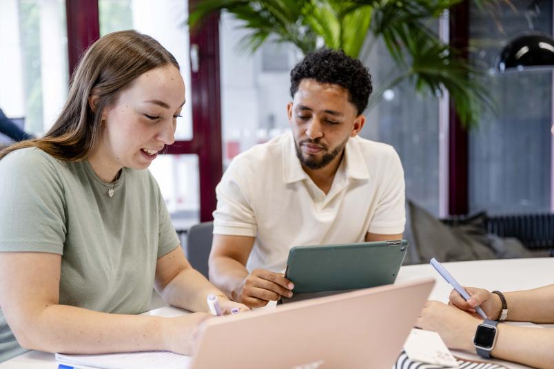 zwei Studis schauen auf Laptop