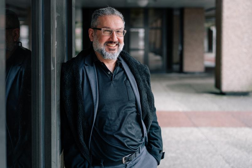 Porträt eines lächelnden Mannes, der an einer Wand lehnt