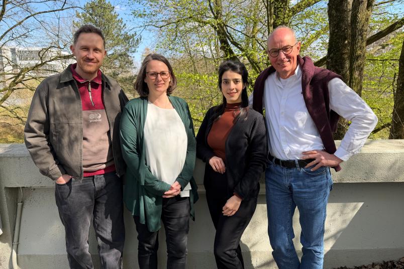 Vier Personen vor einer Mauer