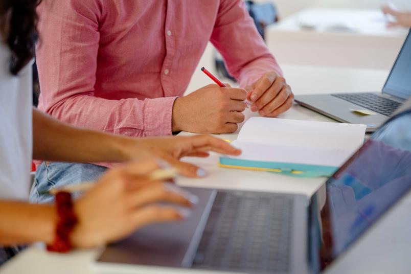 Zwei Personen, die tippen und schreiben