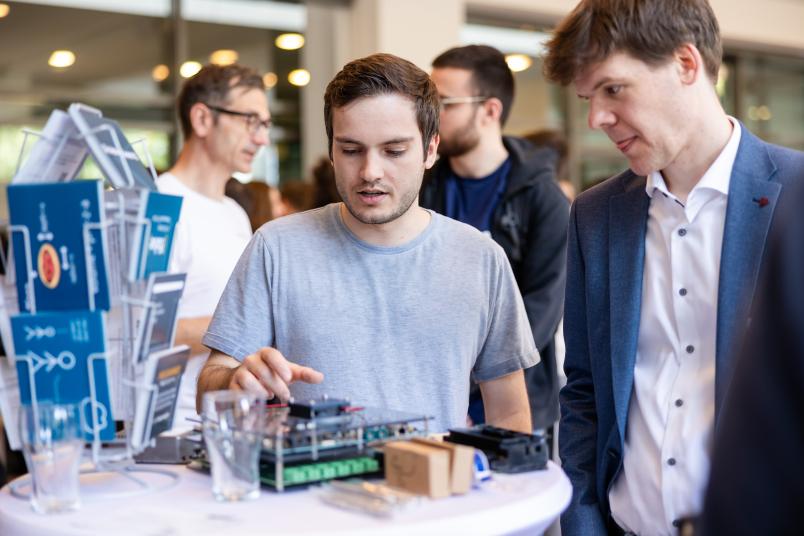 Zwei junge Männer an einem Messestand