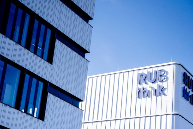 Eine weiße Fassade mit dem blauen Schriftzug "RUB think"
