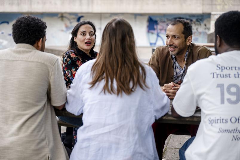 Eine Gruppe junger Menschen am Tisch im Gespräch