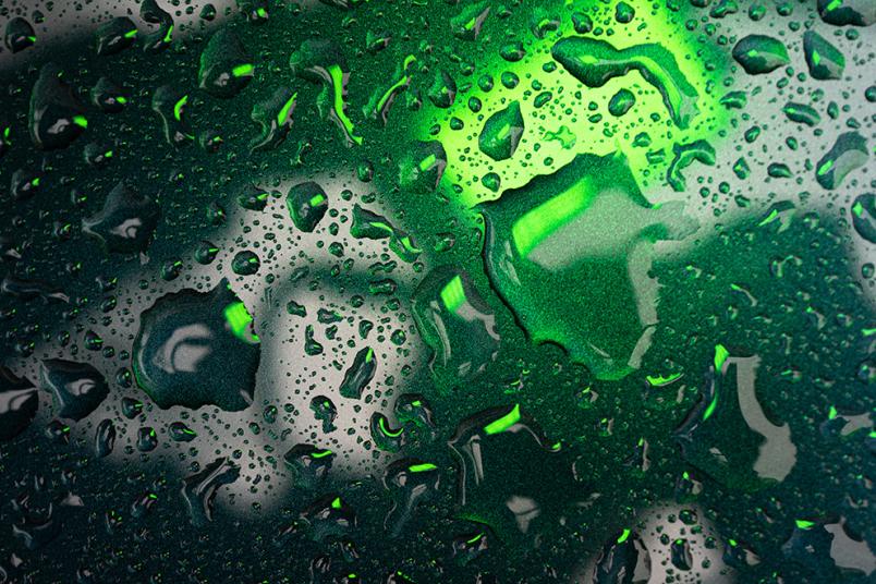 Wassertropfen auf einer schwarz-grünen Oberfläche