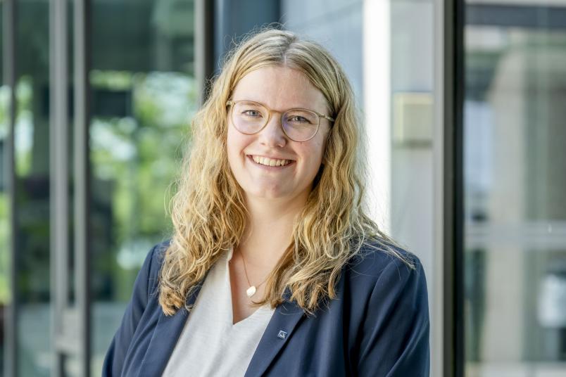 Eine blonde Frau im grauen Jackett