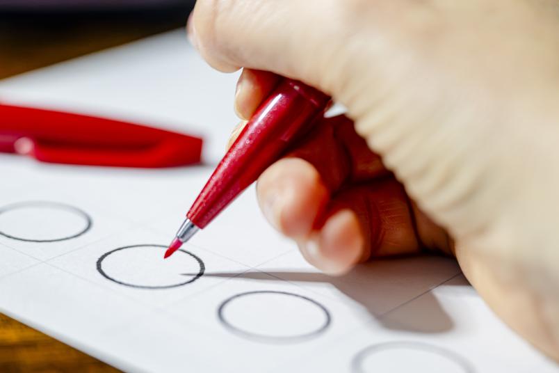 Symbolbild mit einem Wahlzettel und einem Stift