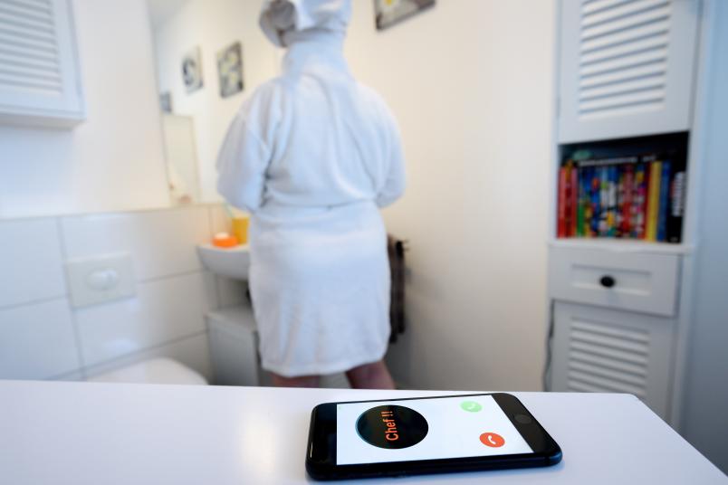 Person im Badezimmer mit Handy