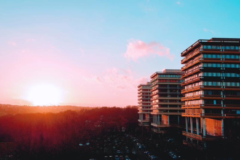 Foto von einer roten Sonne, die hinter dem Campus aufgeht.