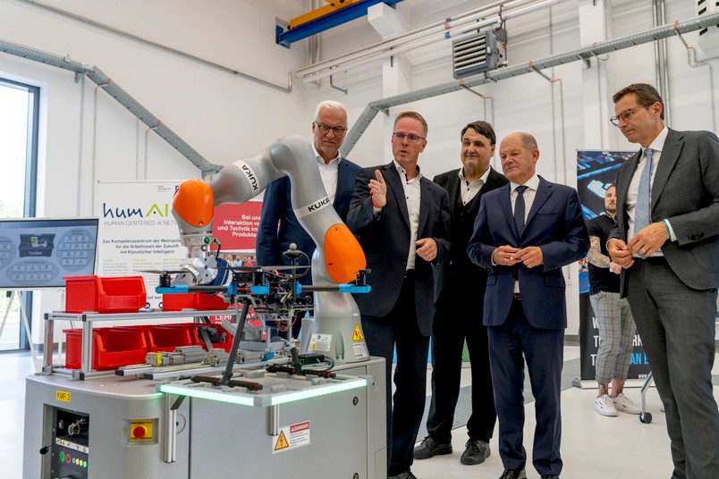 Regionaldirektor Garrelt Duin, ZESS-Direktor Bernd Kuhlenkötter, Rektor Martin Paul, Bundeskanzler Olaf Scholz und Oberbürgermeister Thomas Eiskirch (von links) folgen im Forschungsbau ZESS der Ruhr-Universität Bochum einer Robotik-Demonstration.