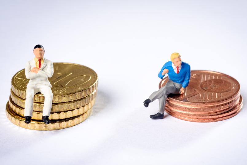 Kleine Figuren auf Stapeln von Geldstücken
