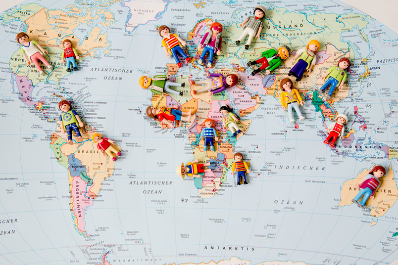 Playmobilfiguren auf einer Weltkarte.