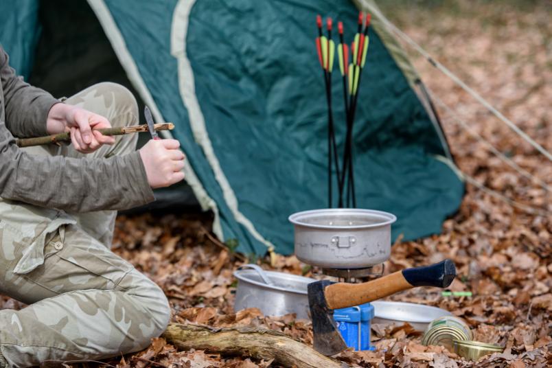 Zelt im Wald mit Axt